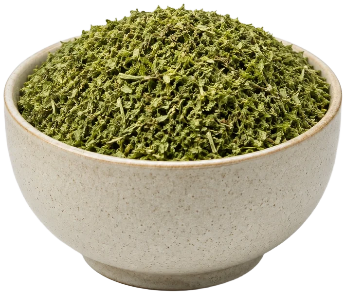 Ceramic bowl of herbs with a tea cup behind